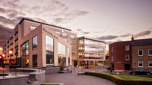 A modern hotel with a prominent sign, a well-lit entrance, and a landscaped outdoor area. - Herbert Park Hotel (Dublin)