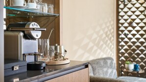 A modern kitchen with a coffee machine, glassware, and a wooden cabinet. - Herbert Park Hotel (Dublin)