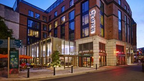 A modern hotel with a prominent sign, large windows, and a well-lit entrance. - The Grafton Hotel (Dublin)