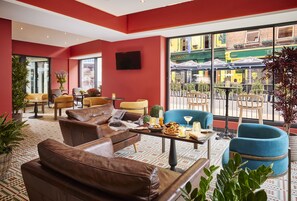 Relax in style with a comfortable sofa, armchair, and chairs, surrounded by lush greenery and a beautiful view.