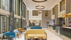A spacious lobby with a central seating area, a reception desk, and a bar. - The Grafton Hotel (Dublin)