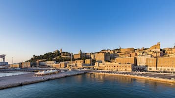 A coastal cityscape with historic buildings, a marina, and a prominent dome structure.