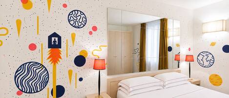 A bedroom with a bed, bedside tables, a mirror, and a wall with abstract patterns.