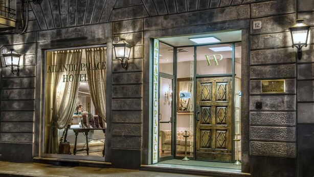 The exterior of the Atlantic Palace Hotel with a large, ornate wooden door and a curtain entrance. - Hotel Atlantic Palace (Florence)