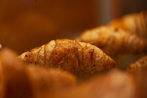 Un primo piano di un croissant con crosta dorata e fragrante.
