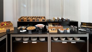 Uma mesa de buffet com diversos alimentos e utensílios de servir.