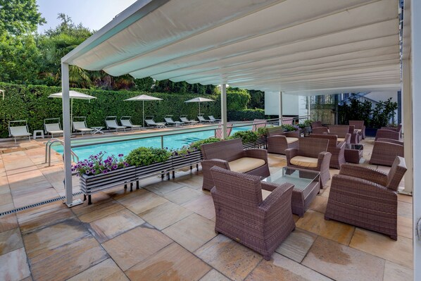 Piscine extérieure en saison, parasols, chaises longues