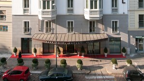 A multi-story hotel with a prominent "HOTEL" sign on the facade, featuring a classic architectural style with balconies and large windows.