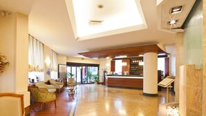 A hotel lobby with a reception desk, seating area, and a skylight. - Hotel Mirage, Sure Hotel Collection by Best Western (Milan)
