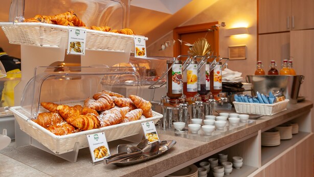 A buffet counter with baskets of croissants and a variety of beverages. - Hotel Mirage, Sure Hotel Collection by Best Western (Milan)