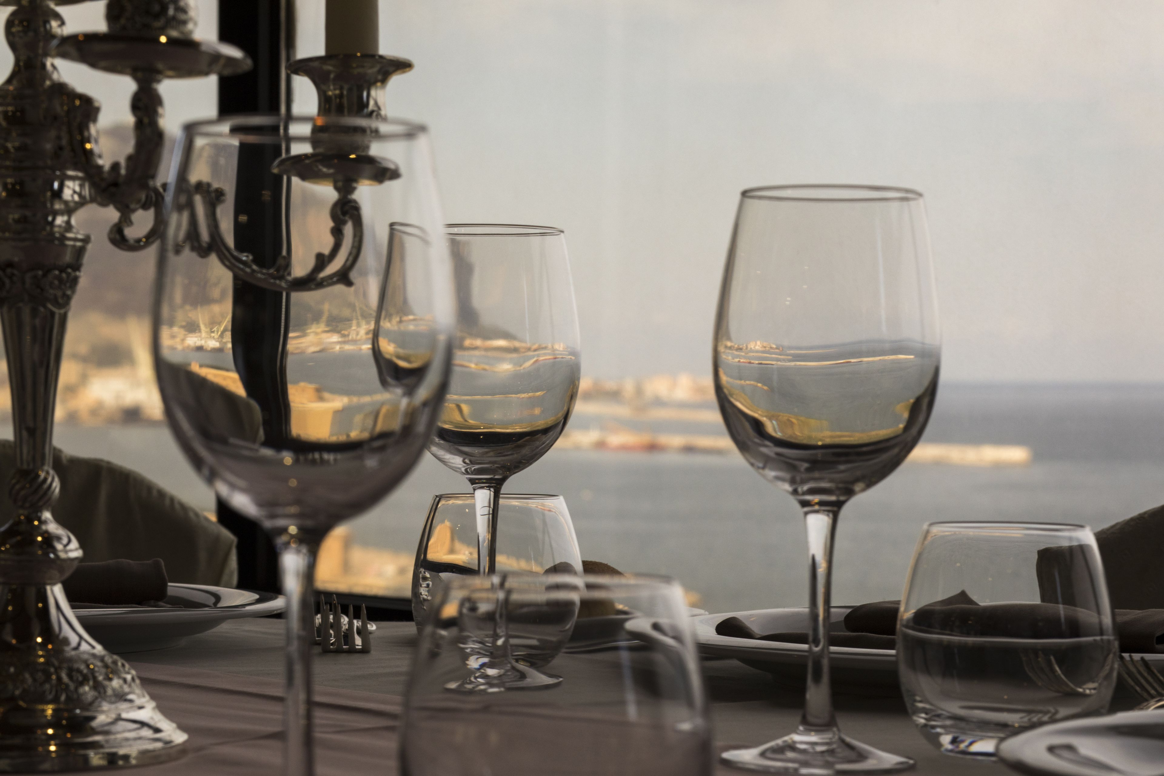 A table set for dining with wine glasses and a candle holder.