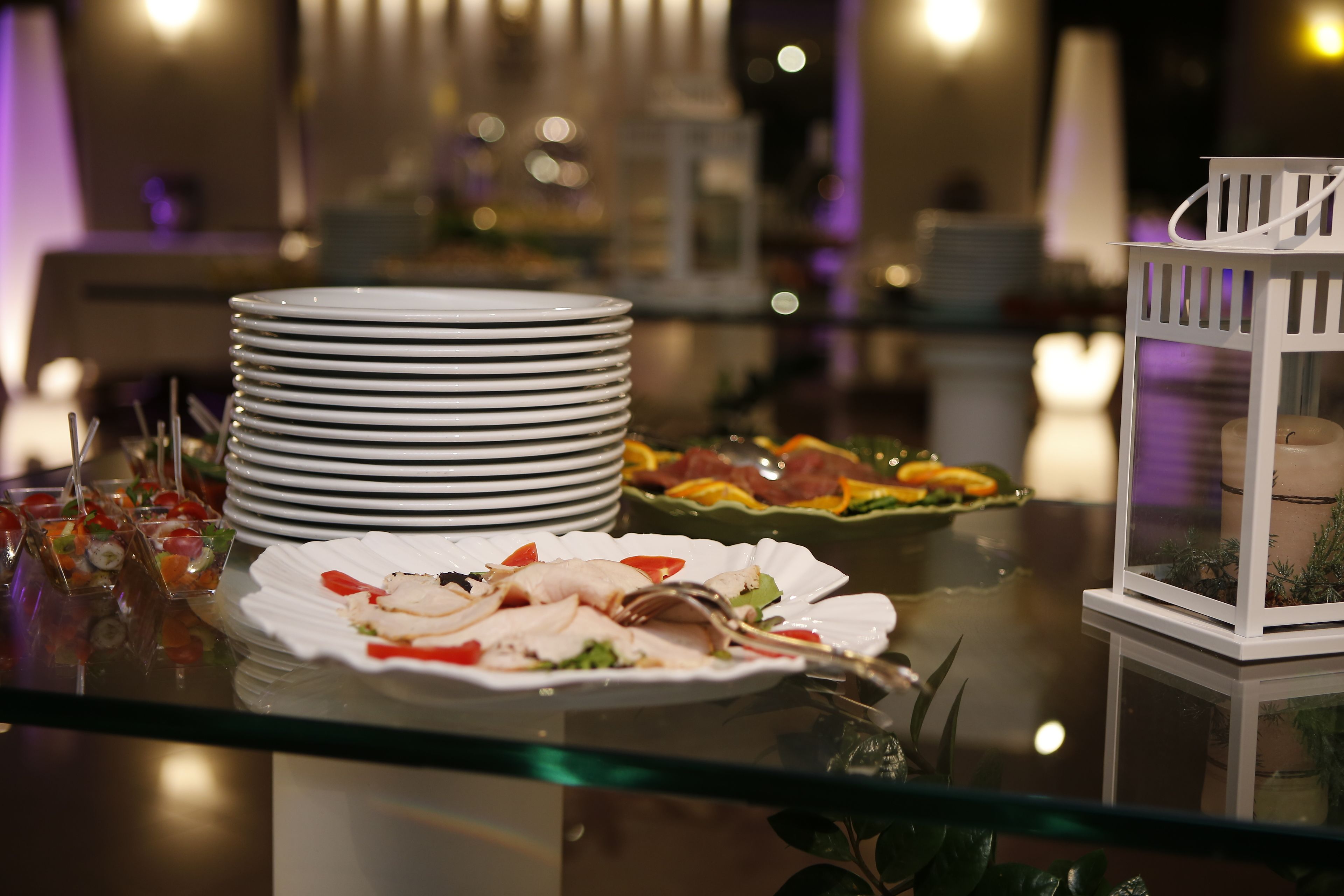 Une table de buffet avec des assiettes, des couverts et divers plats.