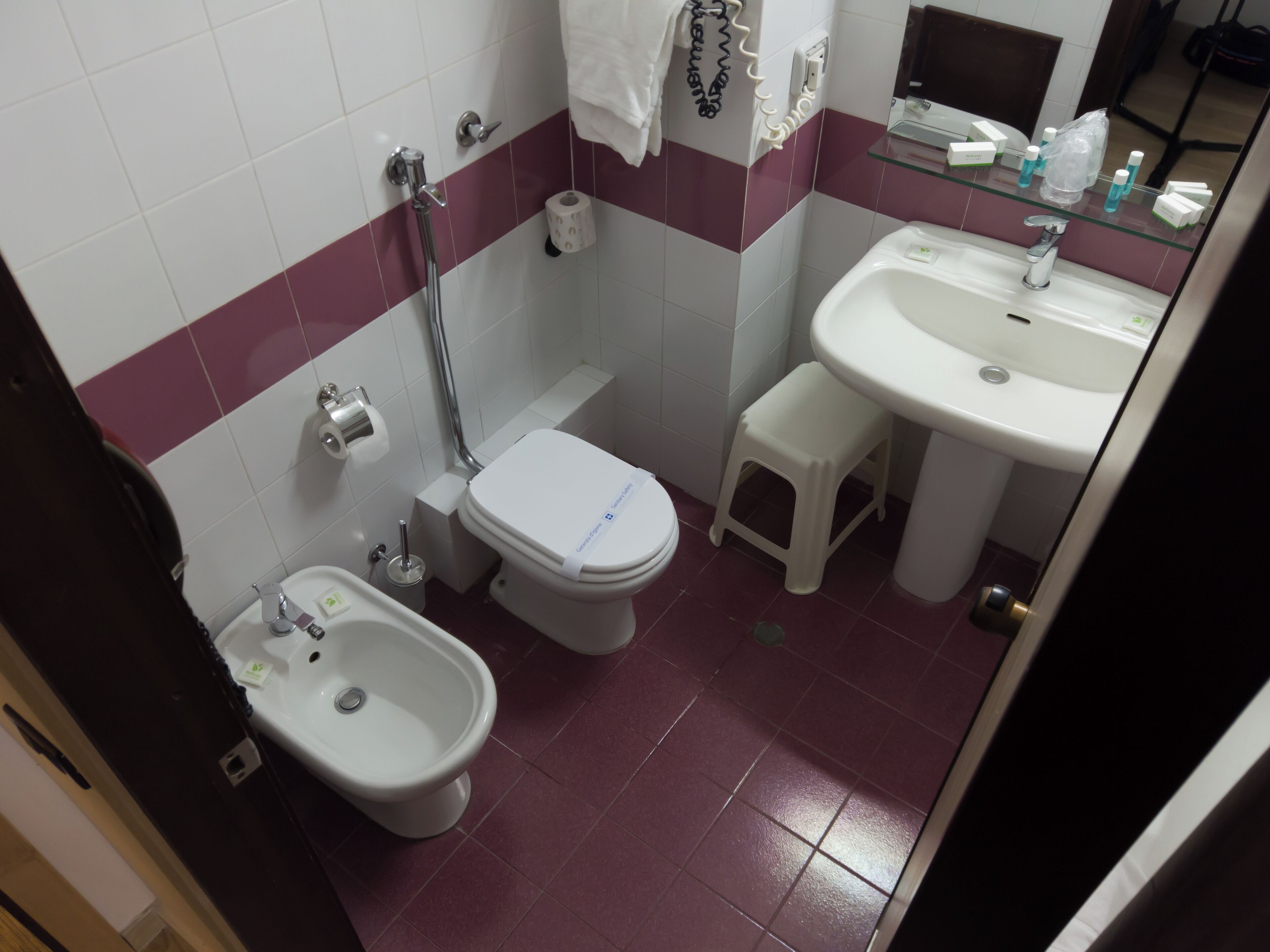 Un bagno piccolo con WC, bidet e lavandino.