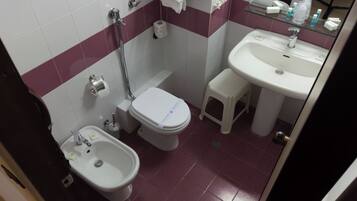 Un bagno piccolo con WC, bidet e lavandino.