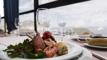 Un plato de mariscos con vistas al mar a través de amplios ventanales.