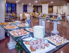 Mesa de buffet con diversas opciones de pastelería y un jarrón decorativo.