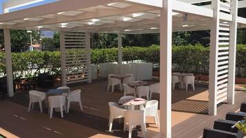 Ein Patio mit weißer Möbel und einer Holzterrasse.