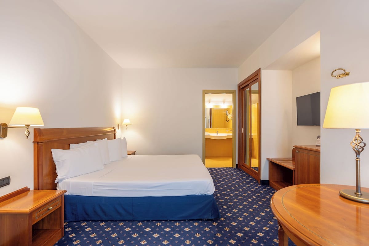 1 kamar tidur, minibar, brankas, dan meja kerja