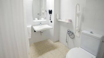 A modern bathroom with a white sink, mirror, toilet, and shower.