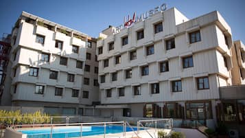Una piscina al aire libre de temporada, sombrillas, tumbonas