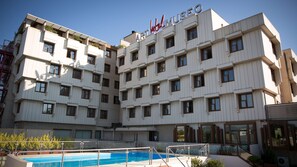 Una piscina al aire libre de temporada, sombrillas