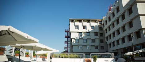 Una piscina al aire libre de temporada, sombrillas, tumbonas