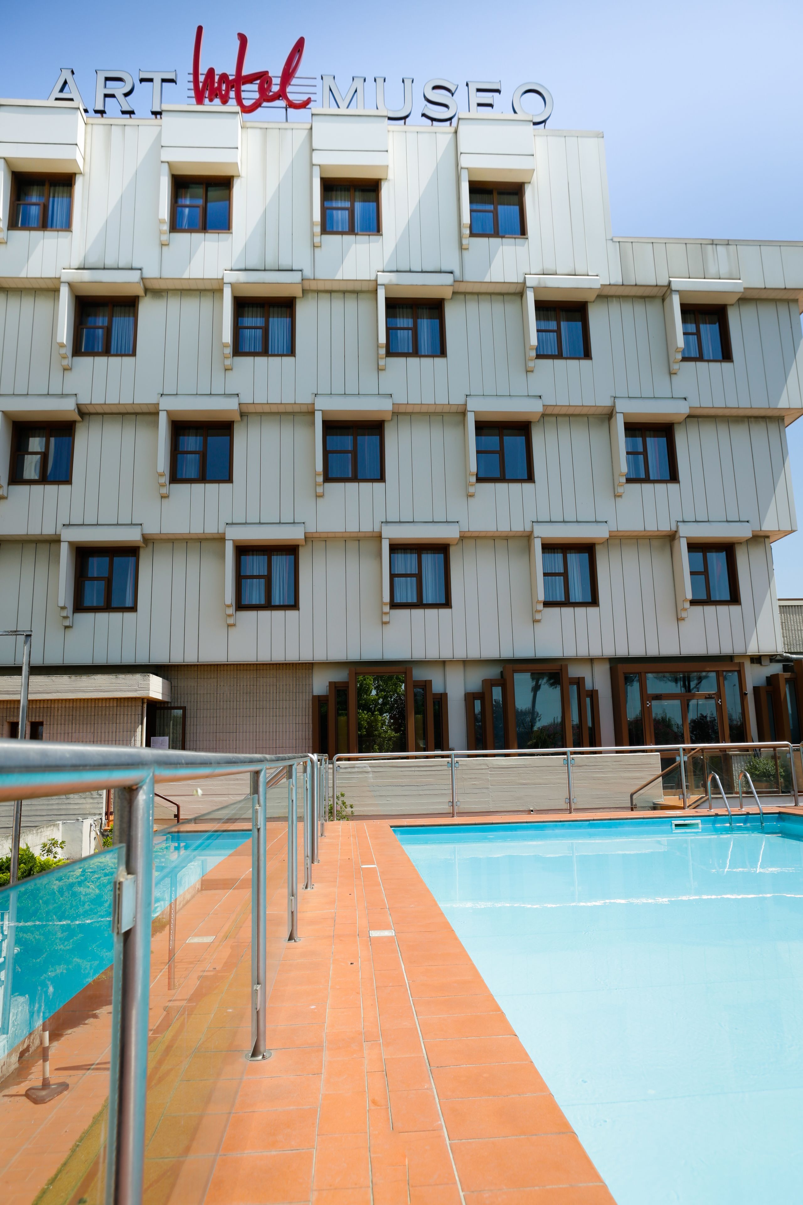 Una piscina al aire libre de temporada, sombrillas