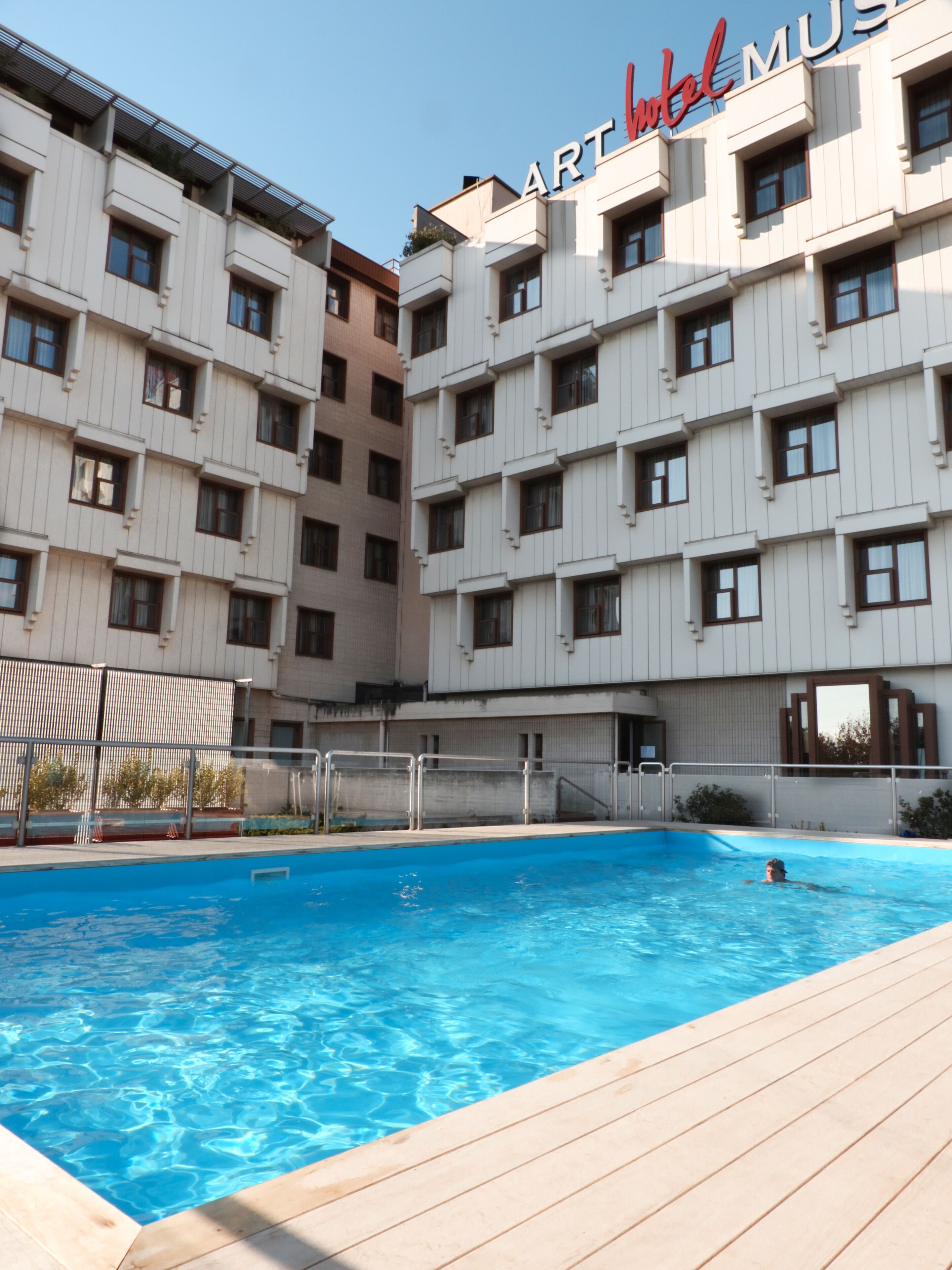 Una piscina al aire libre de temporada, sombrillas