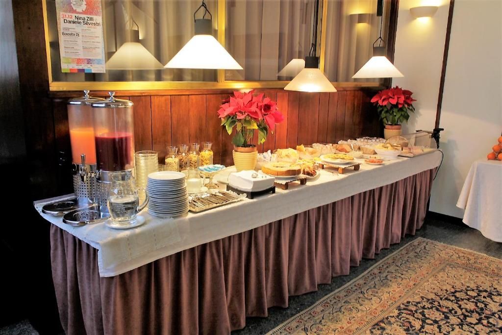 A buffet table with various food items and beverages, a sign with names, and a decorative plant.