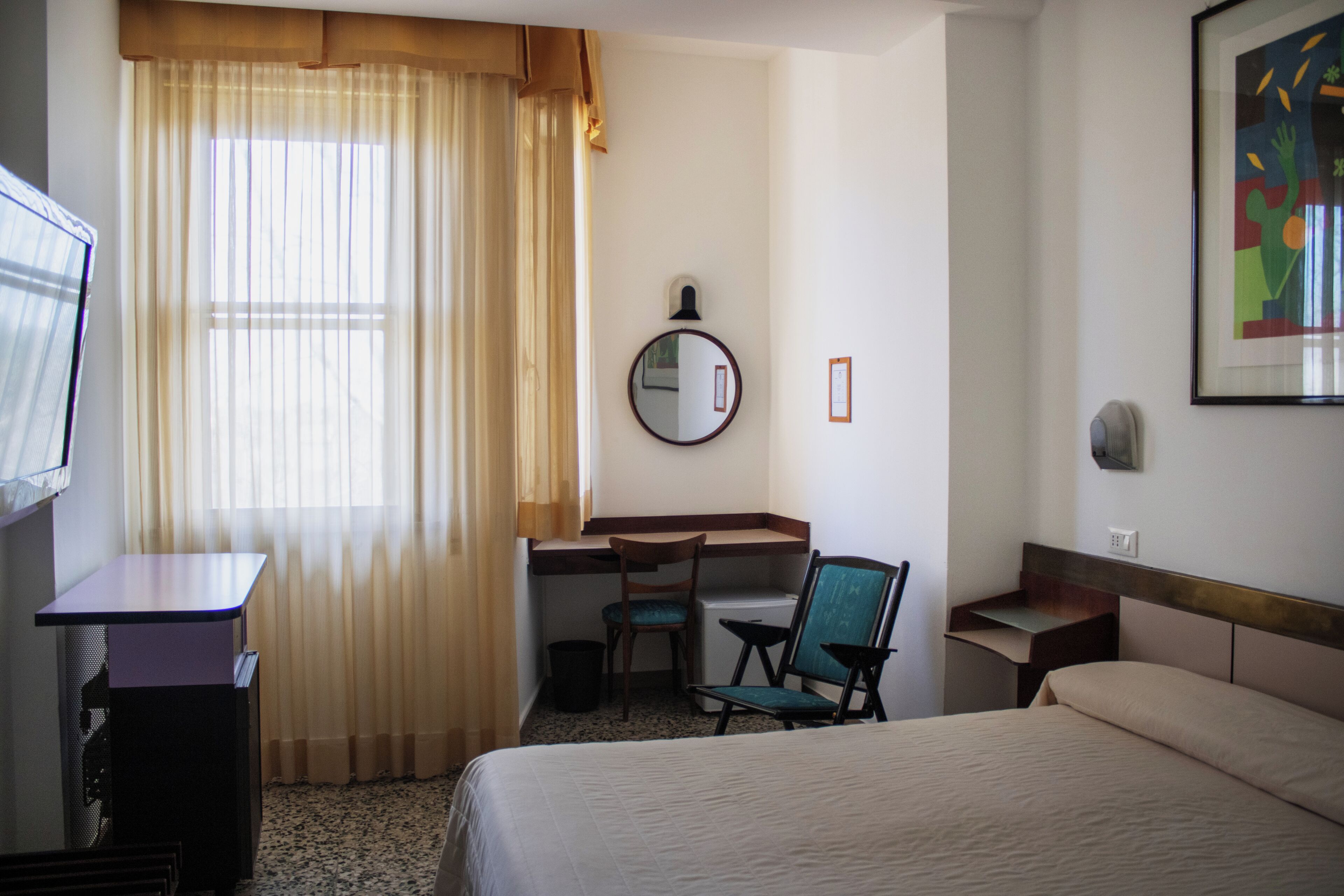 ميني بار وخزنة داخل الغرفة ومكتب وملاءات أسرّة