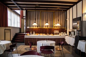 Ein Restaurant mit Barbereich, mehreren Tischen und Stühlen.