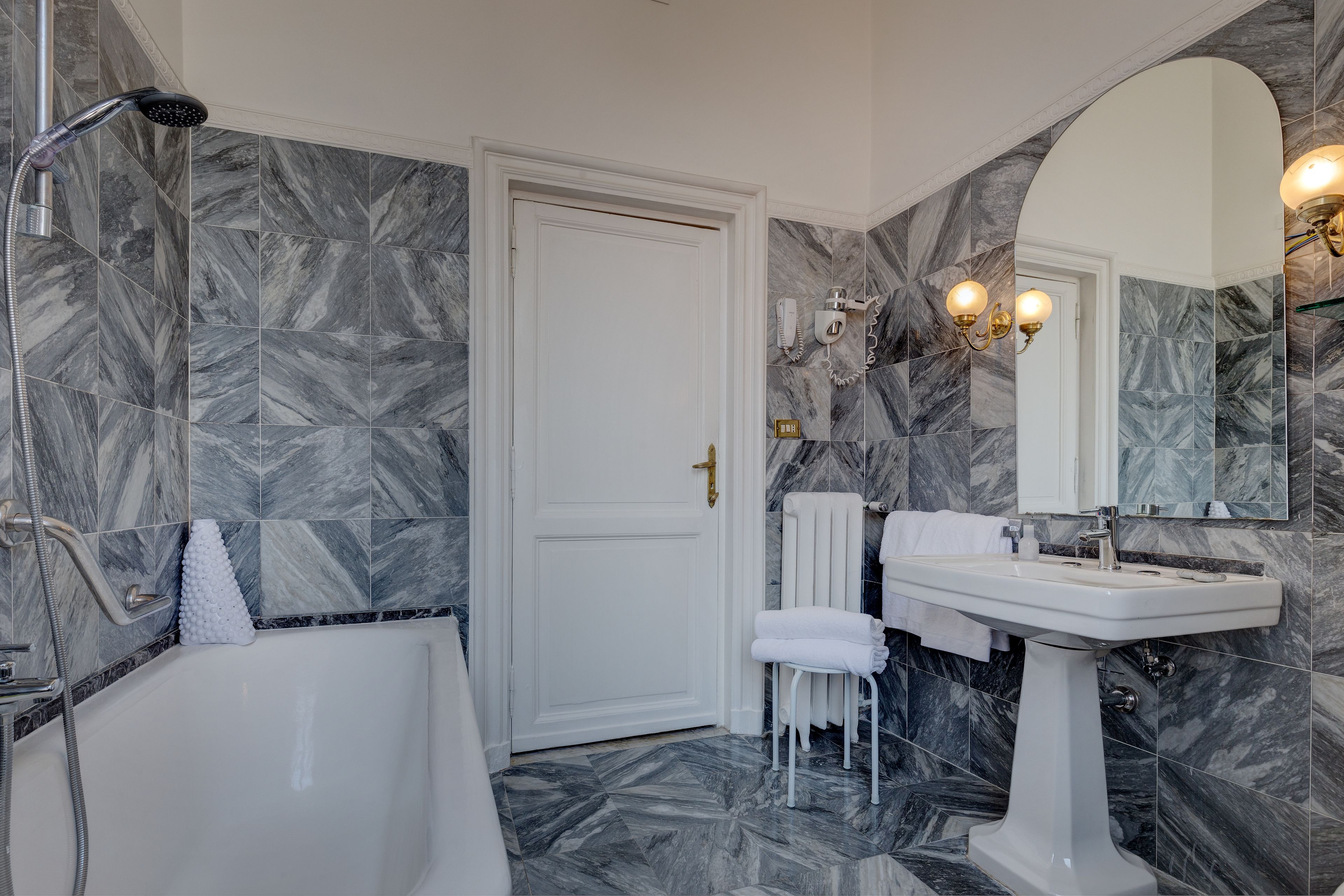 A bathroom with a bathtub, a sink, and a mirror.