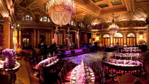 A grand ballroom with ornate chandeliers, a stage, and round tables set for a formal event. - Grand Hotel Plaza (Rome)
