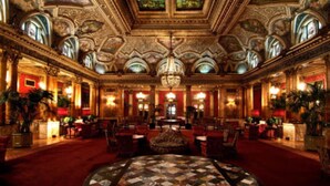 A grand lobby with ornate ceiling details, a central round table, and multiple seating areas. - Grand Hotel Plaza (Rome)