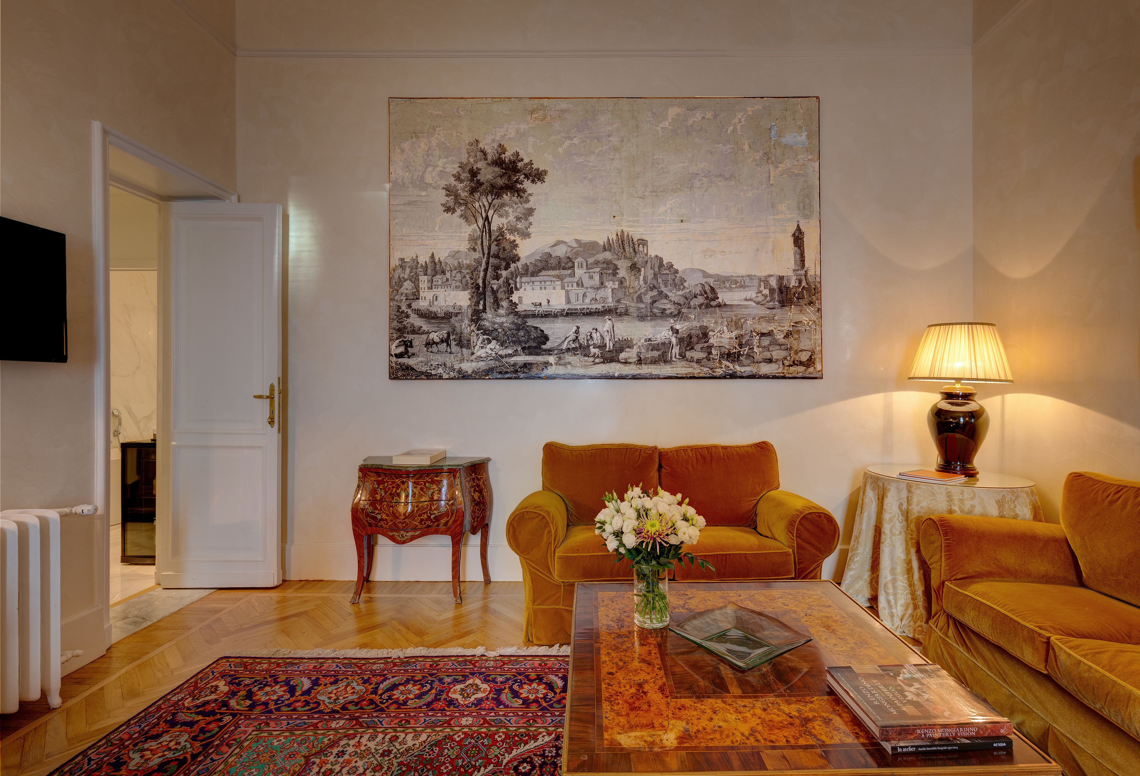 A living room with a sofa, coffee table, and a painting on the wall.