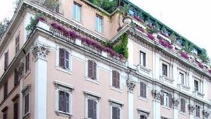 A historic building with multiple floors, large windows, and a central entrance with a canopy. - Grand Hotel Plaza (Rome)