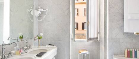 A modern bathroom with two sinks, a large mirror, and a view of the outside through a window.