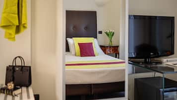 A hotel room with a bed, a television, and a desk with a computer.