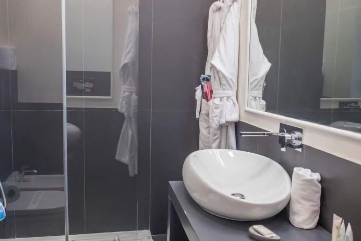 Badkamer | Een bad/douchecombinatie, een regendouche, een haardroger, een bidet