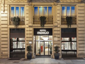 Entrada de un hotel con un cartel que dice "HOTEL INDIGO".
