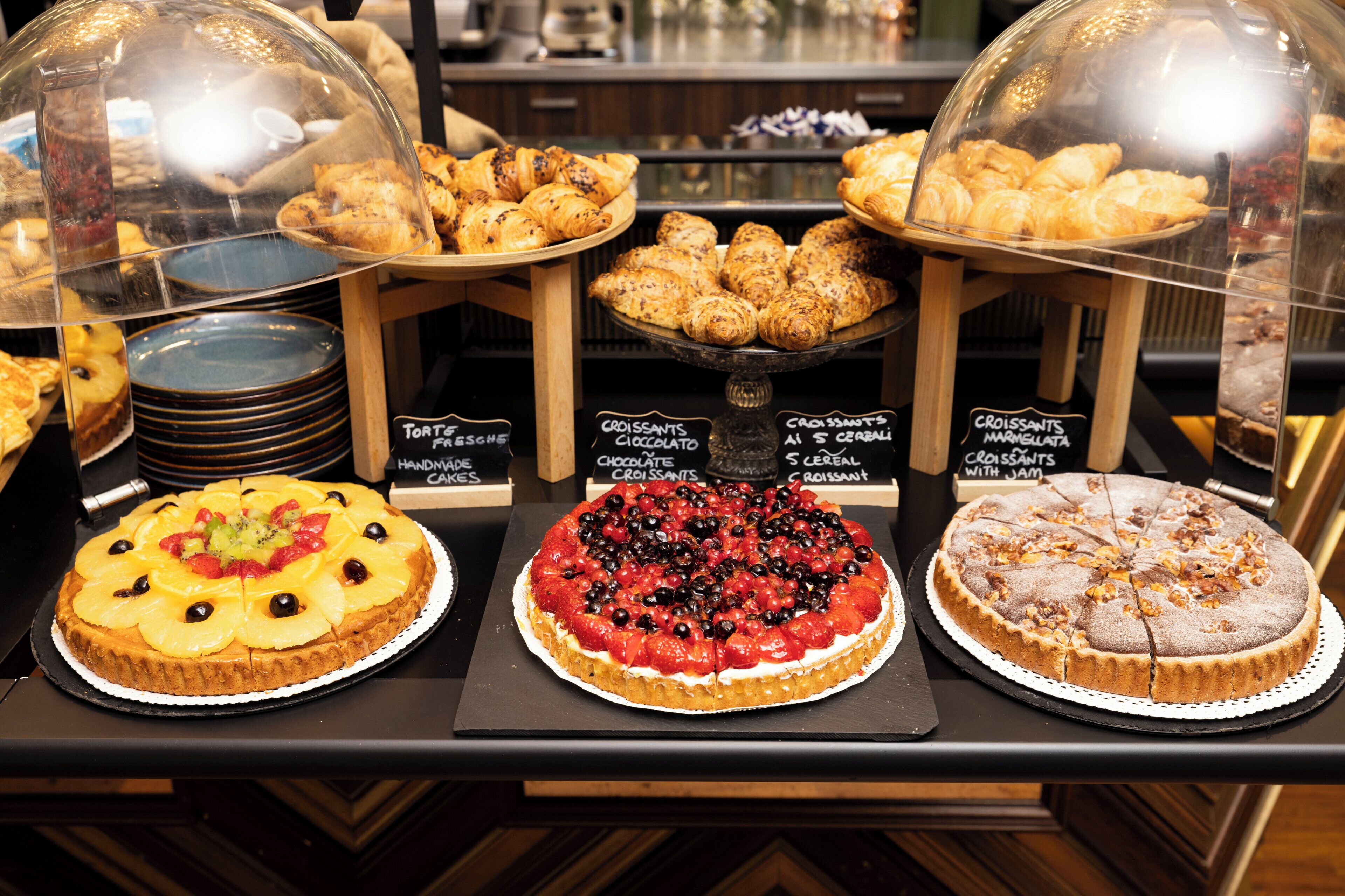 Exhibición de diversos productos de repostería, incluyendo pasteles y tartas, con etiquetas que indican los diferentes tipos.