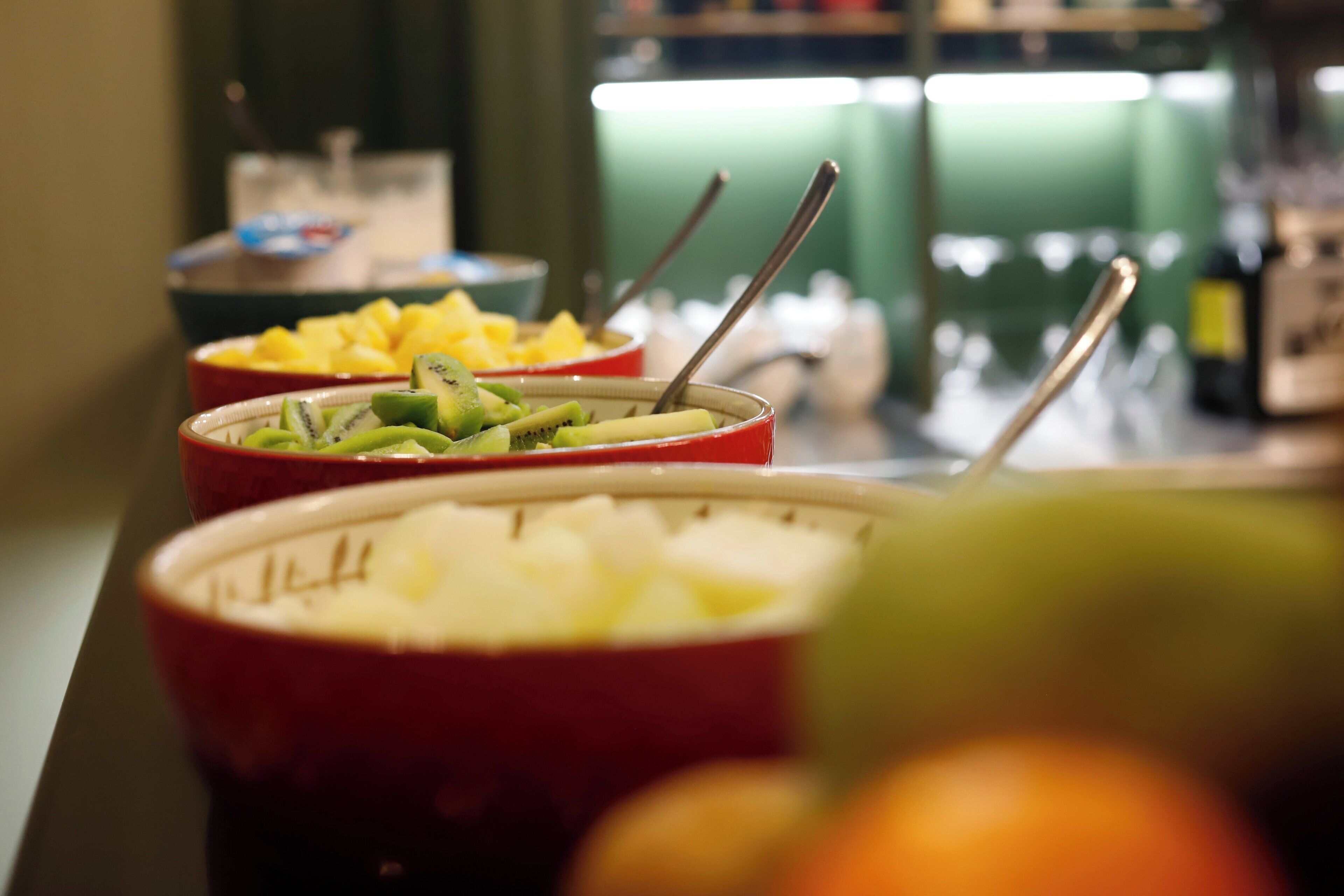 A buffet with various food options including fruits and a beverage.
