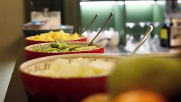 Ein Buffet mit verschiedenen Speisen, darunter Obst und Getränke.