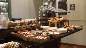 A buffet with various food items and condiments. - Hotel Indigo Turin by IHG (Turin)