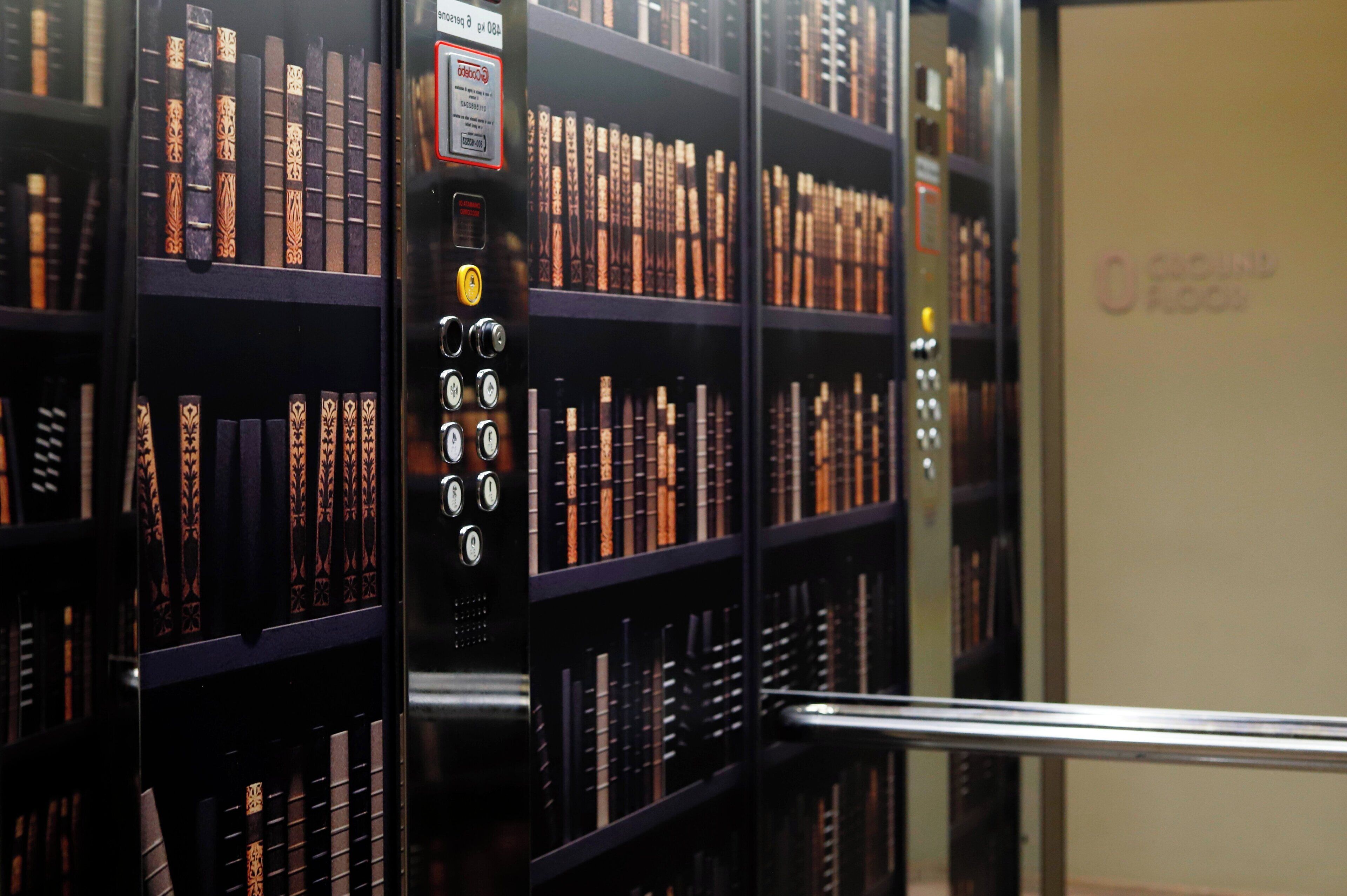 Una biblioteca con estanterías llenas de libros y una máquina para devolverlos.