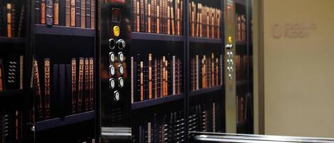 Une bibliothèque avec des étagères remplies de livres et un appareil pour déposer les livres rendus.