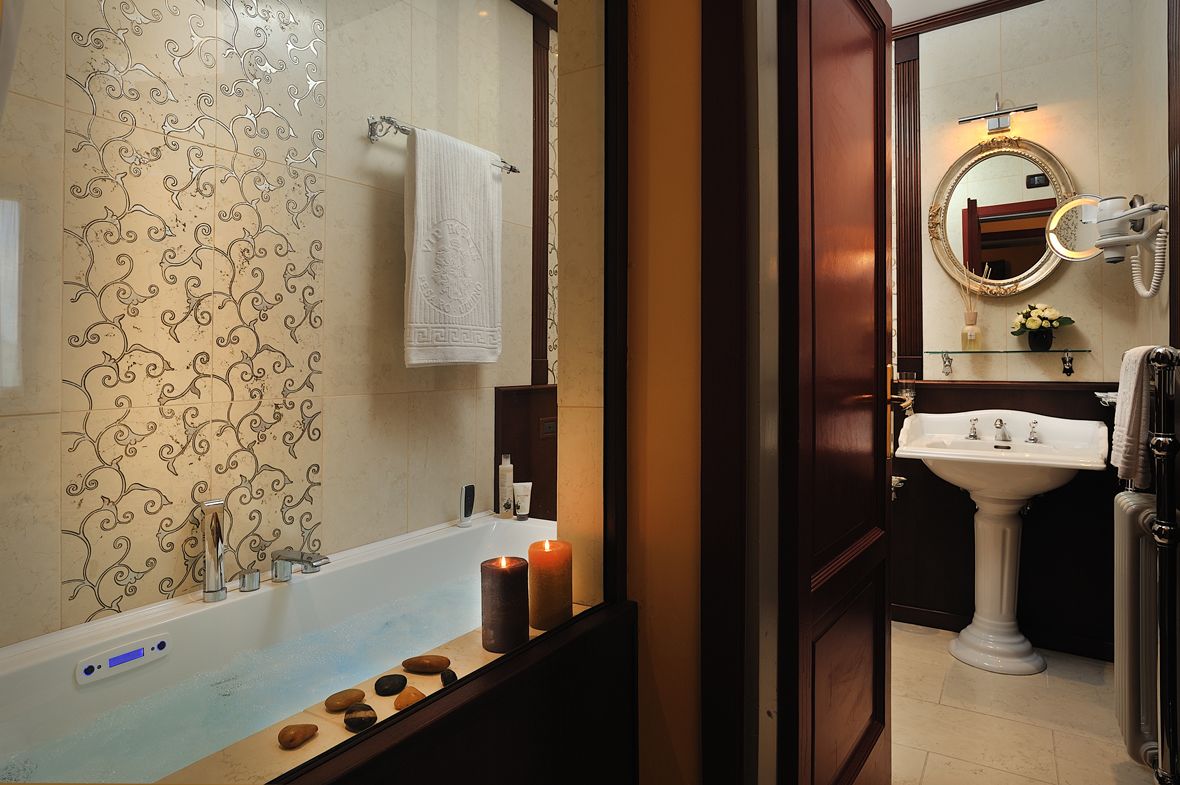 Ein Badezimmer mit Badewanne, Waschbecken, Spiegel und dekorativen Kerzen.