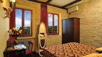 Un dormitorio con cama, cómoda, tocador con espejo, escritorio con silla y ventana con cortinas.
