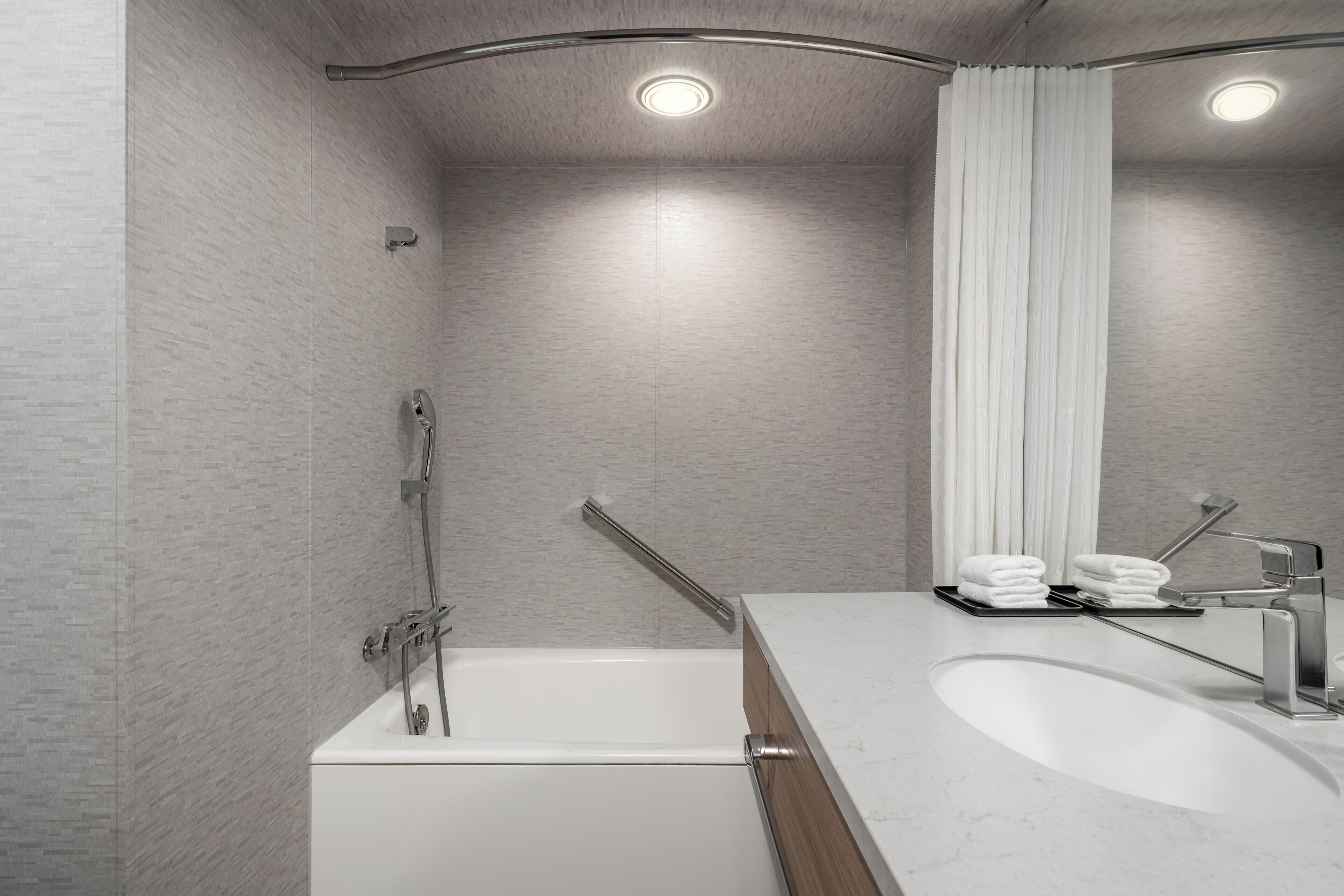 A modern bathroom with a bathtub, a sink, and a shower.