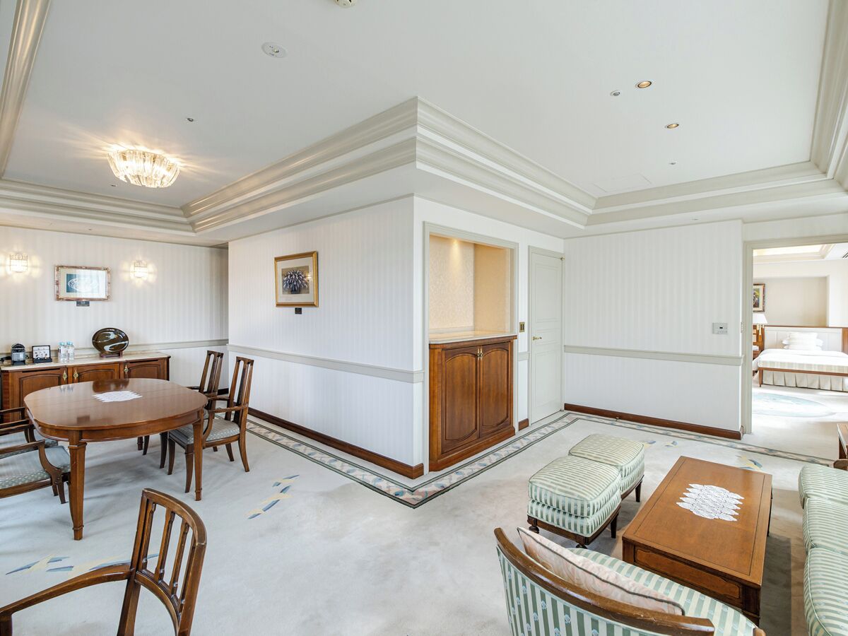 A spacious room with a dining table, chairs, a sofa, and a small table.